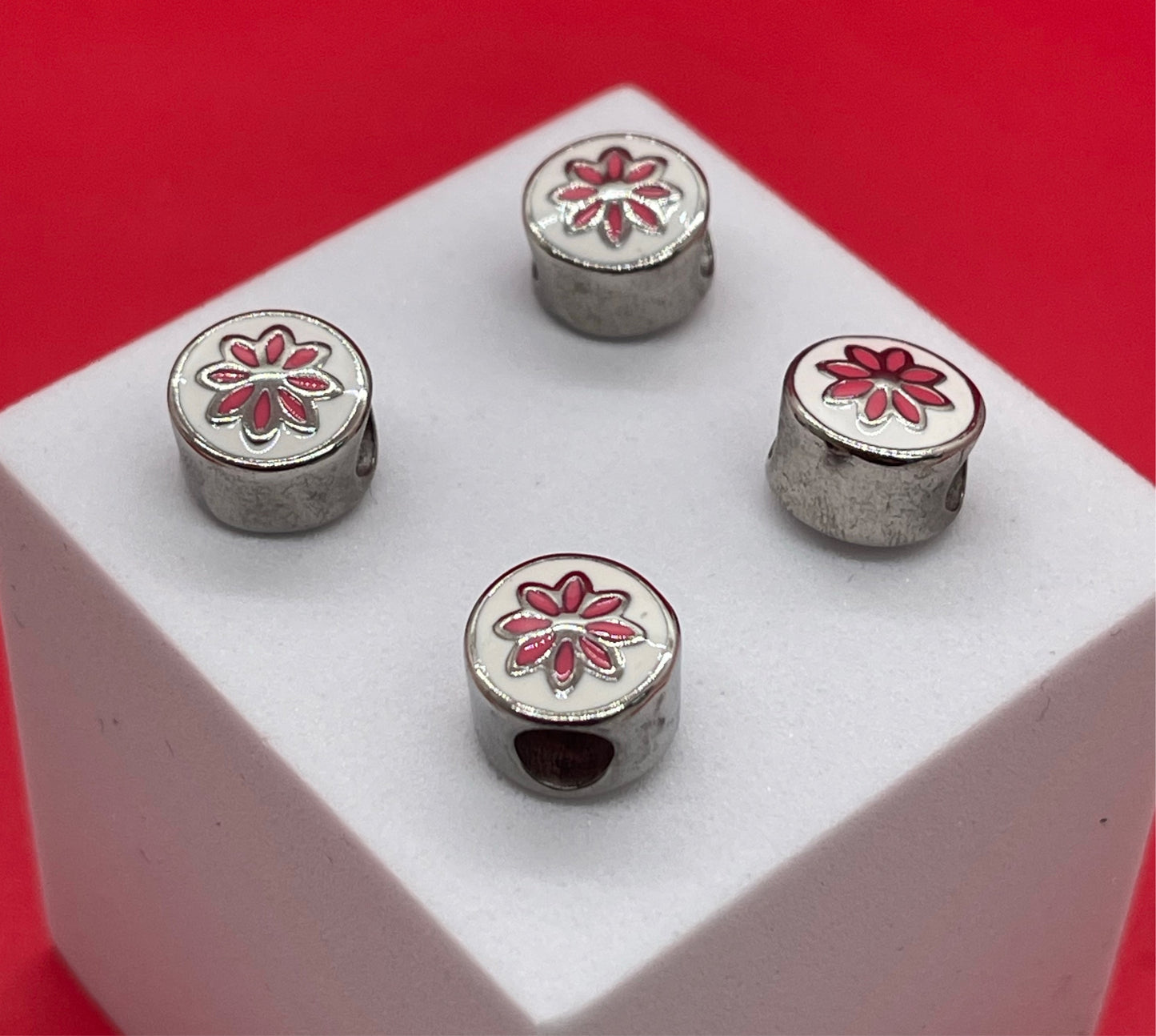 Spacer en stainless steel con flor pintada en rosa Material: Stainless Steel Dimensión: 11 mm Color: dorado Cantidad: 1 pieza SKU: 104536 El color puede ser diferente al de la